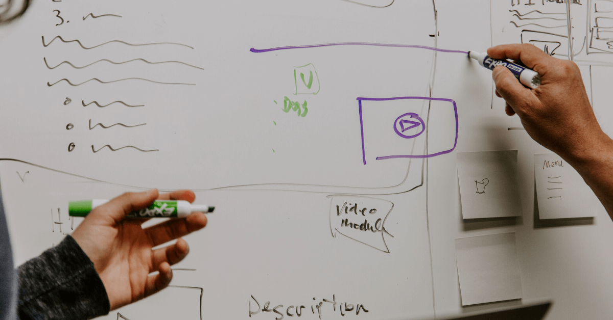 A digital marketing team drawing a strategy on a white board in a company meeting